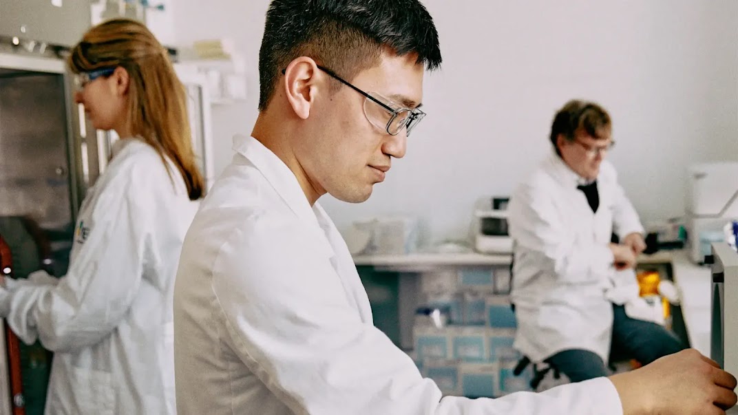 A group of scientists wearing white coats at work.